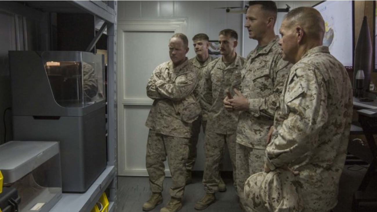 US military personnel around a Markforged system in a deployed setting